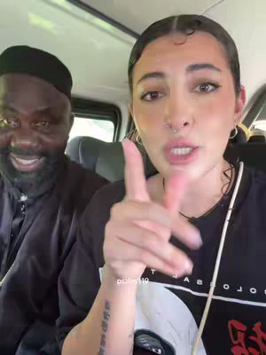 A woman and a man are inside of a car. The woman is pointing with her finger and speaking.