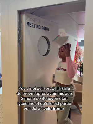 A young woman exits a room, looking over her shoulder with a slight smile. The scene is framed with a door on which reads 'MYSTERY MEETING ROOM.' Text overlays the image, presenting the video's context.