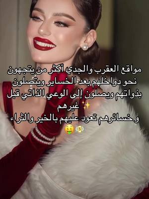 A selfie-style shot featuring a woman with long dark hair and a radiant complexion, adorned with bold red lipstick and expertly applied makeup. She wears a gown with a deep red bodice and a white fur-like wrap, accessorized with pearl earrings and a bracelet. Text in Arabic is overlaid on the image.