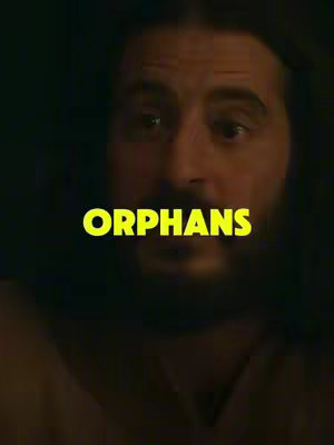 A close-up shot features a man’s face, slightly off-center, in a dimly lit setting. The man, with a beard and long hair, looks directly forward. The text 'ORPHANS' is overlaid in a bright, yellow, bold font.