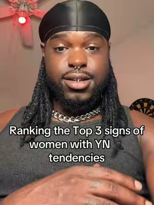 A man with dark skin, wearing a black durag and a silver chain, is facing the camera. The background is slightly out of focus, with a ceiling fan visible. Text overlayed in the image describes the video content.