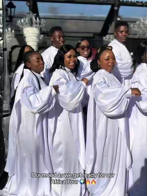 A group of people are gathered outdoors, likely for an event, with a mix of men and women. They are dressed in white robes. In the bottom center of the image, there is text overlay that provides context for the gathering; it is surrounded by an outdoor setting, likely a patio or garden space.