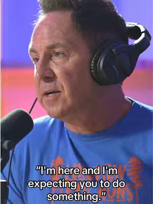 The cover image presents a man seated and holding a microphone, likely in a studio setting. He's wearing a blue shirt and professional headphones. The background has a gradient of colors, suggesting studio lighting. The man is speaking and there's overlaid text at the bottom that reads: "I'm here and I'm expecting you to do something."