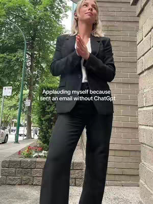 The image shows a woman standing in profile outdoors. She is wearing a black suit with a white shirt. The woman's hands are clasped together in front of her, seemingly in prayer or applause. The background includes a brick wall and greenery. A text overlay mentions ChatGPT.