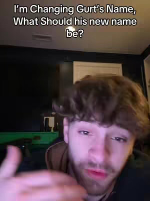A man with a beard and short hair is in a close-up shot, the background is a dark room. Text overlay says, 'I'm Changing Gurt's Name, What Should his new name be?'