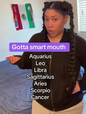 A woman with braided pigtails poses in front of a light-colored wall, a Mexican flag hangs on the wall. A purple rectangular text bubble in the center of the frame reads "Gotta smart mouth," with several zodiac signs listed below.
