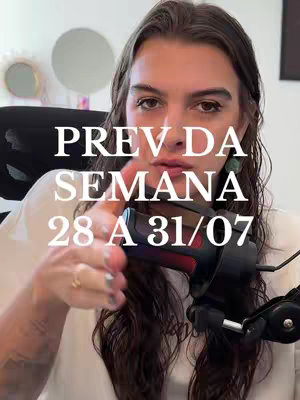 A woman with long, dark hair holds a microphone in front of her. Text overlayed on the image reads, "PREV DA SEMANA 28 A 31/07". The scene includes a blurred background with a decorative mirror.