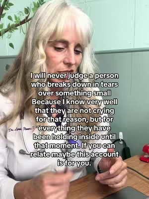 A woman with long blonde hair and a white coat is centered in the shot, appearing to be in a medical environment. Text overlayed on the image provides a message on empathy and emotional release.