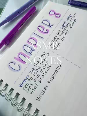 A close-up shot of a notebook open on the desk, with colorful pens and the title 'CHAPTER 8' in large, stylized letters. The page shows notes on viruses, with the text in a handwritten font and the background slightly blurred.