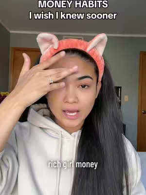 A woman with long dark hair and a headband is looking at the camera. The text overlay says "MONEY HABITS I wish I knew sooner", there is also text saying "rich girl money".