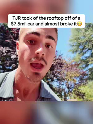 The image features a young man with a short haircut and a mustache, speaking directly towards the camera. He's wearing a light-colored shirt with trees and foliage in the background. A text overlay at the top indicates a story about a car.