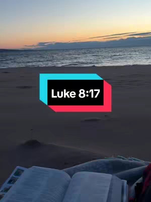 The image captures a serene beach scene during the golden hour. The ocean stretches to the horizon under a sky painted with the warm hues of sunset. A rectangular box in the center, colored in shades of turquoise and red, contains the text 'Luke 8:17'. A partially visible open book lies in the foreground on what appears to be the sandy beach.