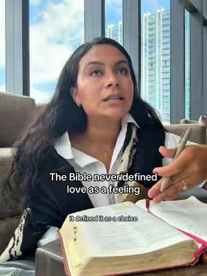 The cover image features a woman with long, dark hair, wearing a white shirt and black vest, sitting indoors with a Bible open in front of her. Another person's hand is visible, holding a pen and pointing towards the Bible. The background includes a window with a view of tall buildings and a neutral-toned interior.