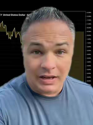 A man with graying hair and a light blue shirt looks directly at the camera. Behind him is a chart with a downward-sloping yellow line, indicating a financial trend, set against a dark background. The overall composition suggests a focus on economic or financial analysis.