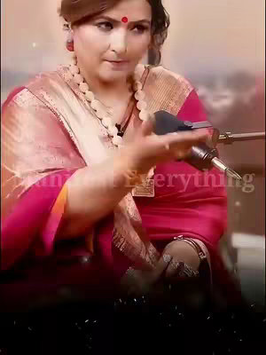 The image features a woman with a red bindi on her forehead wearing a pink saree and a white beaded necklace. She is holding a microphone up to her face. Text overlayed on the image that says "I can Everything"