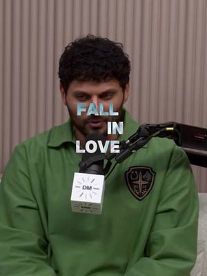 A medium shot features a man speaking into a microphone, with the words 'FALL IN LOVE' overlaid across his body. He is wearing a green jacket. The background is a neutral, textured wall.