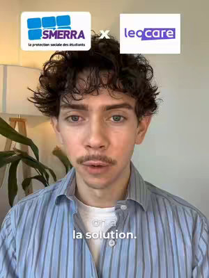 A young man with curly dark hair and a mustache is centered in the frame, facing the camera. Above him, two logos are displayed: one for "SMERRA" and another for "Leocare". The background is slightly blurred, including a lamp and a plant, suggesting an indoor setting. He wears a light blue striped shirt, and the overall lighting is natural.