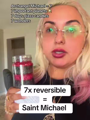 A woman with blonde hair and glasses holds a candle in front of her. Text overlays display information about the candle and numbers relating to Archangel Michael.