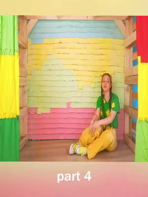 A woman sits cross-legged In a colorful room. The room is a wooden structure painted with various colors. She wears a green shirt and yellow pants. The text "part 4" appears at the bottom.