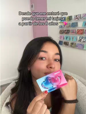 A young woman with long dark hair is holding a Pixpay card up to her mouth in front of her face, with text overlayed on the image. She is in a well-lit room with a light pink wall behind her.