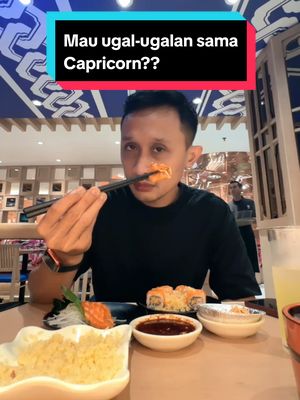 A man holds chopsticks with a piece of food in front of his mouth, with visible sushi, sauces, and background dining setting, overlaid with a blue and red text box.