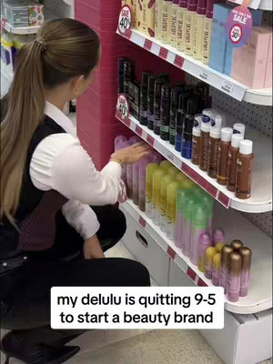 A woman in a white blouse and black vest, facing away, arranges products on a store shelf filled with beauty products. The shelves are pink, and the text overlay says, "my delulu is quitting 9-5 to start a beauty brand."