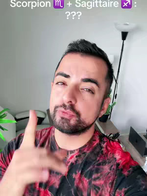 A man with a beard and short hair, wearing a red and black patterned shirt, is pointing upward with his right index finger. Above him, text reads "Scorpion + Sagittaire : ???" in white. The background has a white wall.