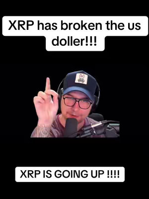 A man with glasses, a baseball cap with a logo, and a microphone is in focus against a black background. Text overlays read 'XRP has broken the us doller!!!' and 'XRP IS GOING UP !!!!'. He is raising his index finger as if making a point.