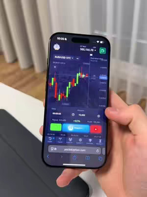 The cover image shows a smartphone displaying a trading app interface. The app's screen displays a candlestick chart with red and green candlesticks, along with numerical data and buttons for trading actions. A hand holds the phone against a bright, simple background.