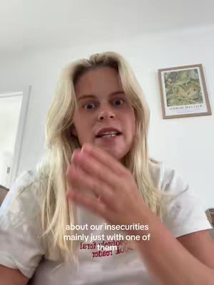 The cover image features a woman with long blonde hair speaking into the camera. Her face is expressive, likely in mid-sentence, with her hand raised near her face. The background is a white wall with a framed picture on it. The image is well-lit, with a focus on the woman's face and upper body.