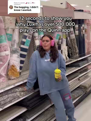 A woman wearing pink headphones and a blue hoodie stands in a store aisle. Text overlaid says, "12 seconds to show you why Lux has over 500,000 plays on the Quinn app."