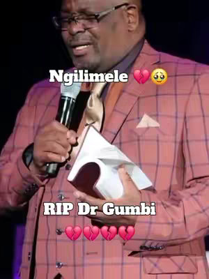 An older Black man in a pink plaid suit is speaking into a microphone. Text overlays include "Ngilimele" with a broken heart and crying emoji, and "RIP Dr Gumbi" with broken heart emojis.