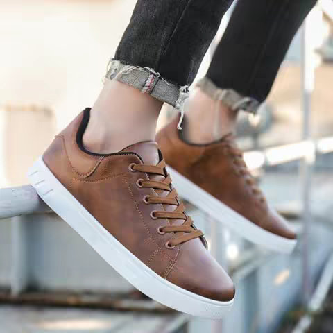 The cover image shows a close-up of a person's feet wearing brown sneakers with white soles, set outdoors. The focus is on the shoes, showcasing a brown leather material, white soles, and brown laces. The person wearing the shoes has dark denim jeans on.