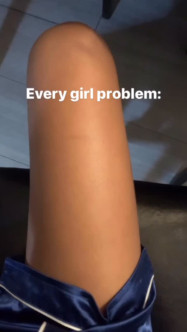 The image focuses on a woman's leg, from mid-thigh to just below the knee. She is wearing dark blue satin pajamas, and the leg is angled, creating a sense of depth. The skin tone is light brown, and there's a text overlay at the top.