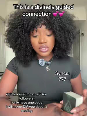A woman with dark, curly hair and a black top looks directly at the camera. Text overlays at the top read, 'This is a divinely guided connection' with pink heart emojis. Other text at the bottom advertises the creator's social handle and disclaims DM contacts, while displaying the word 'Syncs' followed by '777'. She's holding a deck of cards in her right hand.