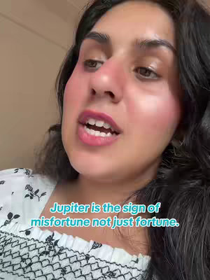 The cover image shows a close-up of a woman's face. She has dark hair, and her skin is fair with noticeable blush. She is looking upwards and to the side, with her mouth slightly open as though she is speaking. A text overlay at the bottom reads: “Jupiter is the sign of misfortune not just fortune.” The background is subtly blurred, suggesting an indoor setting.