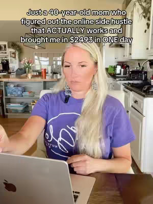 A woman with long blonde hair is sitting at a table, looking at a laptop. Text overlays the top of the screen.