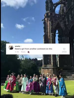 The cover image shows a group of people dressed in traditional Korean clothing standing on a grassy area in front of a large stone building next to a cloudy sky. There is a social media comment overlayed on the image.