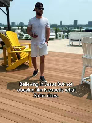 The cover image shows a man standing on a wooden deck outdoors on a sunny day. The man is wearing a white t-shirt, shorts, black sneakers, a black baseball cap, and sunglasses. He's holding a phone in one hand and has a thoughtful expression. In the background, there are buildings, trees, and a lake. Overlayed text at the bottom reads: 'Believing in Jesus But not obeying him is exactly what Satan does.'
