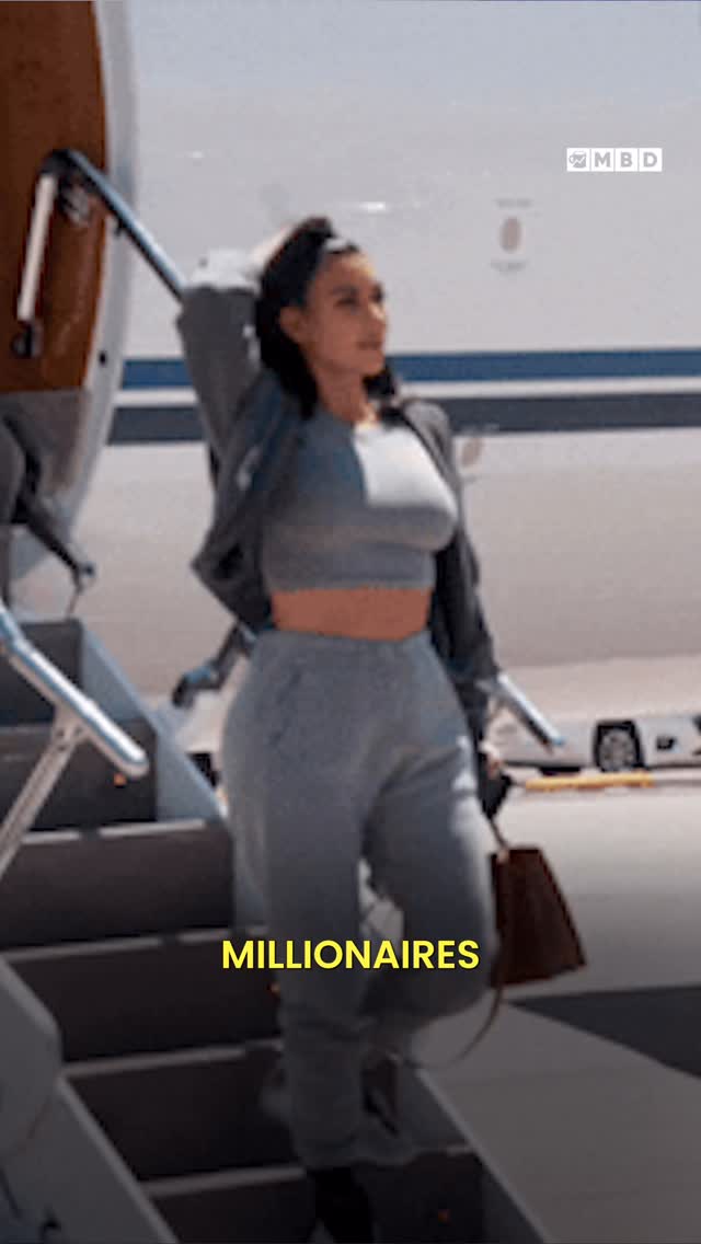 A woman in a gray crop top and sweatpants exits a private jet. The background features the plane, stairs, and a sunny sky.