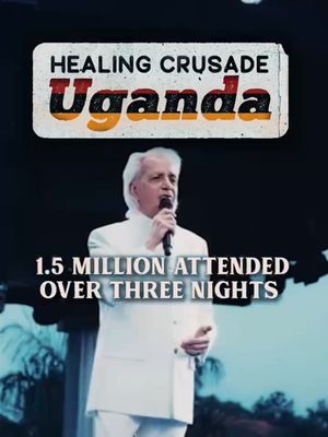 The image is a vertical shot featuring a man speaking into a microphone on a stage. Above him is a rectangular banner with text indicating the event as a "HEALING CRUSADE Uganda." Below this banner is text that reads "1.5 MILLION ATTENDED OVER THREE NIGHTS". The man is dressed in a white suit and is centered in the frame. The background is a dark, out-of-focus setting, possibly a large indoor space.