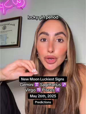 A woman with long, light brown hair looks directly at the camera. The top third of the frame features overlay text on a black background with the lucky signs and the date of the new moon for this astrological prediction video. The background is a bright wall and there is a framed document on the wall. The text also includes the name of the new moon luckiest signs