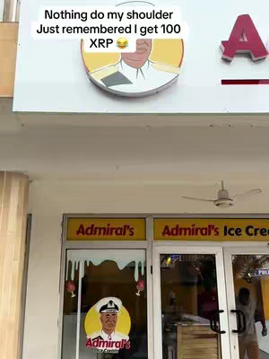 The image is a street scene showing a storefront with signs related to the Admiral's brand. The signs are yellow with red lettering. Above the storefront, text is overlaid on the image. The overall composition is a shot taken at eye-level.