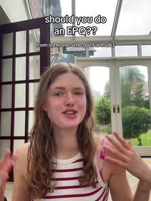 A young woman in a striped tank top talks directly to the camera with her hands animated in front of a glass-walled room.