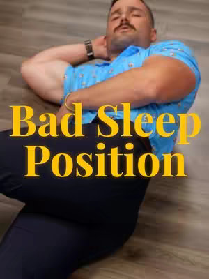 A man lies on a wooden floor, presumably in a bed-related setting, with his arms behind his head. Text overlays read 'Bad Sleep Position' in large, yellow, outlined letters. The man wears a blue patterned shirt and dark pants. The lighting appears natural.