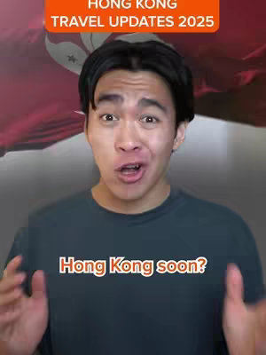A young man with dark hair and a gray t-shirt is centered in the frame, with his hands raised. He is against a background of the Hong Kong flag. The text overlay is orange and white.