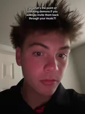 A close-up shot of a person with short, spiky hair, looking at the camera with a serious expression. The background is a plain white wall. Text overlay is present.