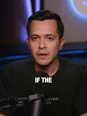 A man in a black shirt sits in front of a microphone. The background has blurred lights. Overlay text "IF THE".