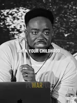 A black and white image features a man in a close-up shot. He appears to be looking slightly to the side, possibly as if speaking. Overlayed text reads 'WHEN YOUR CHILDHOOD'. The background is softly blurred.