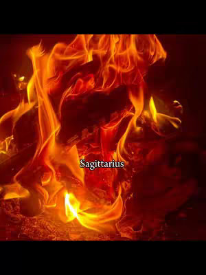 The image depicts a fiery scene with bright orange and red flames filling the frame. The flames appear to be from a fire with a dark background. Within the flames, the word 'Sagittarius' is written in a light-colored font. The overall composition is dynamic, with the fire creating a sense of energy and intensity.